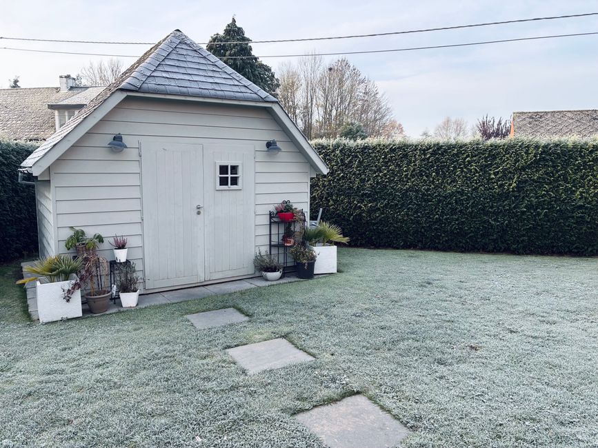 Minimalistisch tuinhuisje omringd door groene planten. Minimalistisch tuinhuisje omringd door groene planten.